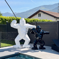 Kongari Collection — sculptures gorille origami H200 cm Blanc Alpin et H150 cm Noir Onyx côte à côte, au bord d'une piscine en Valais