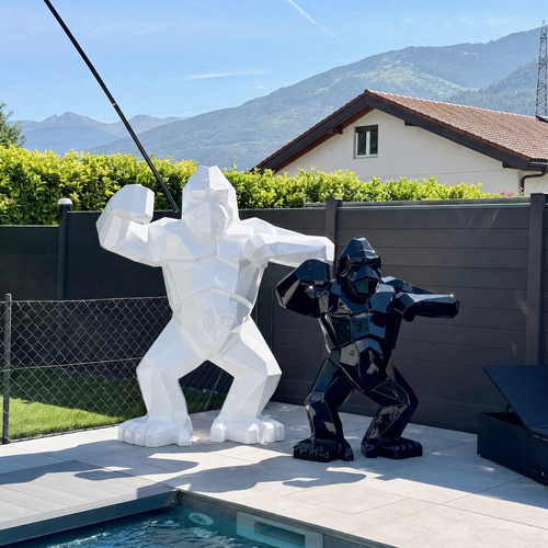 Kongari Collection — sculptures gorille origami H200 cm Blanc Alpin et H150 cm Noir Onyx côte à côte, au bord d'une piscine en Valais
