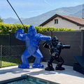 Kongari Collection — sculptures gorille origami H200 cm Bleu Voltage et H150 cm Noir Onyx côte à côte, au bord d'une piscine en Valais