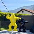 Kongari Collection — sculptures gorille origami H200 cm Jaune Helios et H150 cm Noir Onyx côte à côte, au bord d'une piscine en Valais