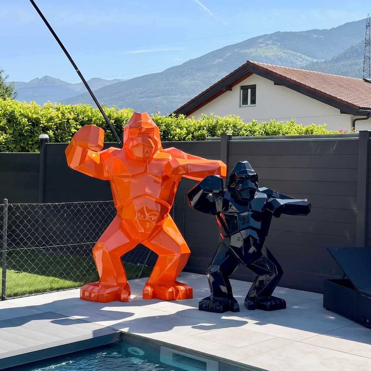 Kongari Collection — sculptures gorille origami H200 cm Orange Fusion et H150 cm Noir Onyx côte à côte, au bord d'une piscine en Valais