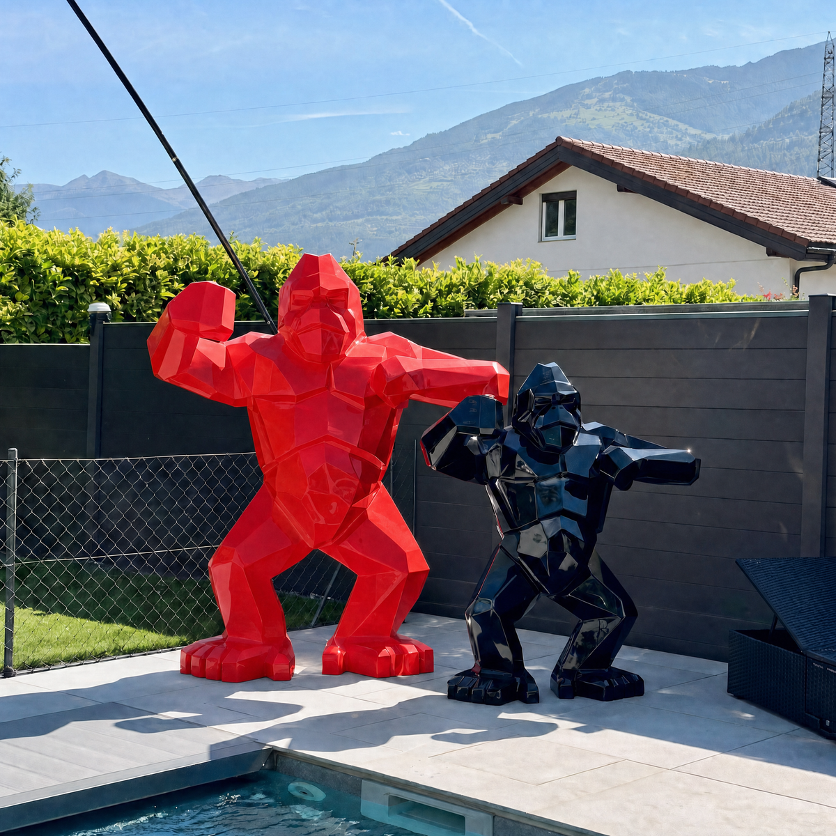 Kongari Collection — sculptures gorille origami H200 cm Rouge Helvete et H150 cm Noir Onyx côte à côte, au bord d'une piscine en Valais