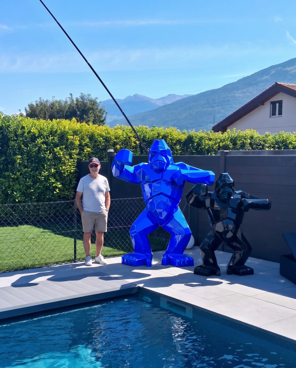 Kongari Collection — sculpture gorille origami Bleu Voltage H200 cm, 2 mètres de haut comparés à un adulte, installée au bord d'une piscine en Valais, Suisse