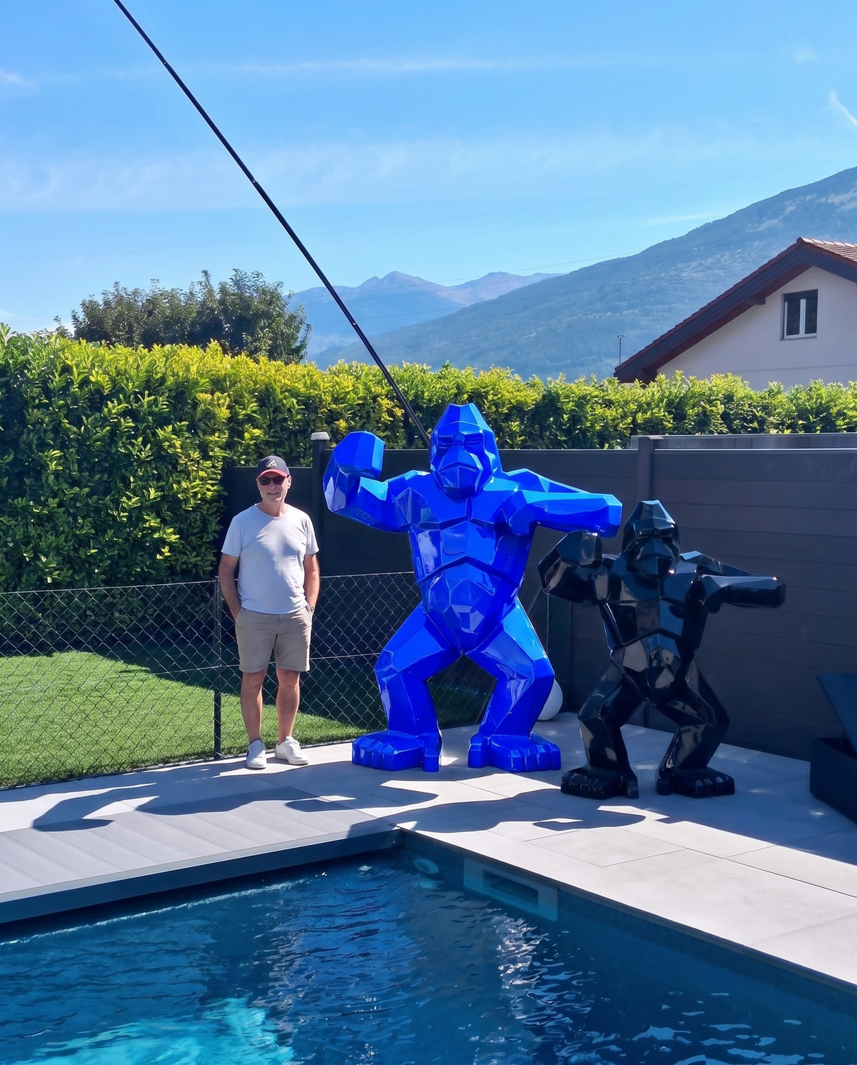 Kongari Collection — sculpture gorille origami Bleu Voltage H200 cm, 2 mètres de haut comparés à un adulte, installée au bord d'une piscine en Valais, Suisse