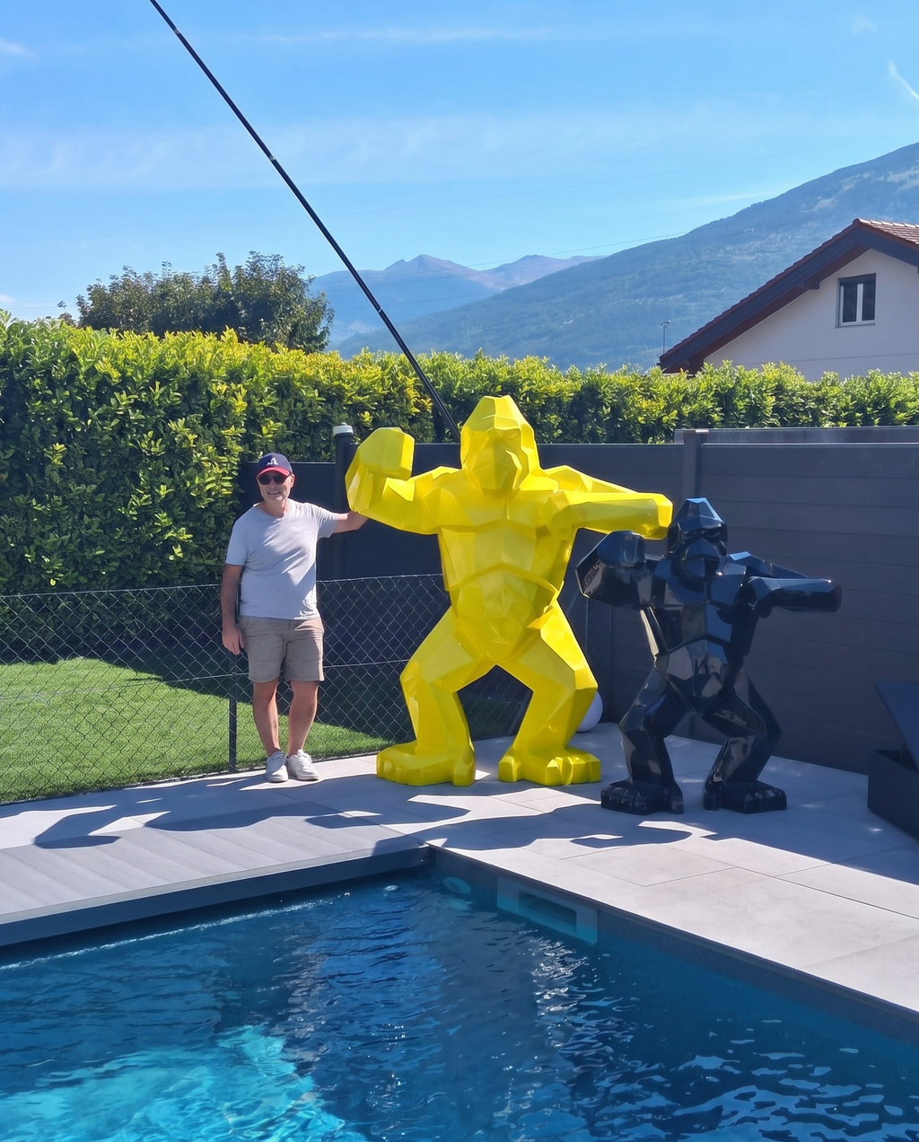 Kongari Collection — sculpture gorille origami Jaune Helios H200 cm, 2 mètres de haut comparés à un adulte, installée au bord d'une piscine en Valais, Suisse