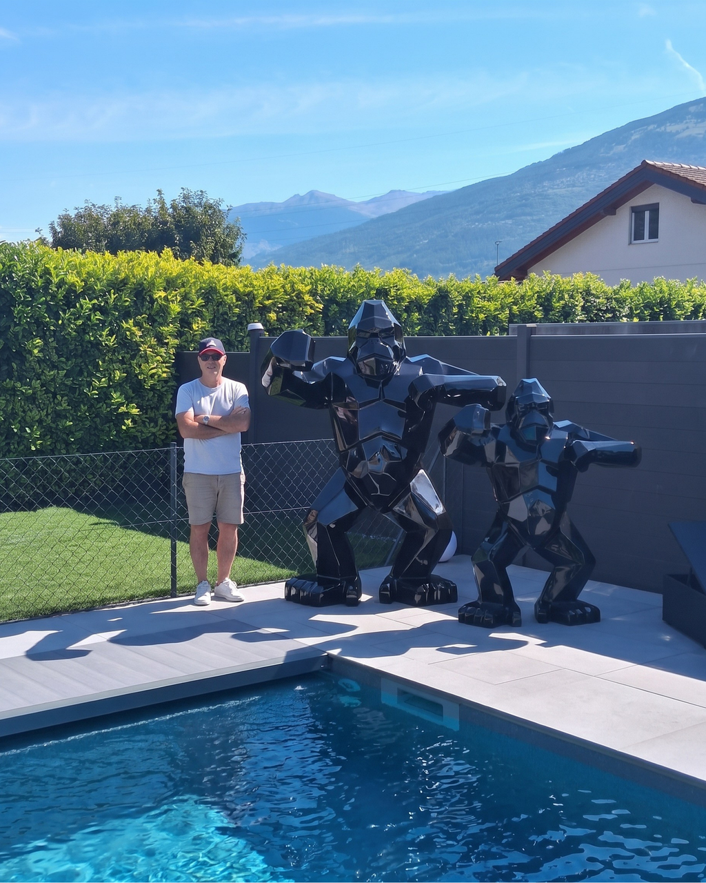Kongari Collection — sculpture gorille origami Noir Onyx H200 cm, 2 mètres de haut comparés à un adulte, installée au bord d'une piscine en Valais, Suisse