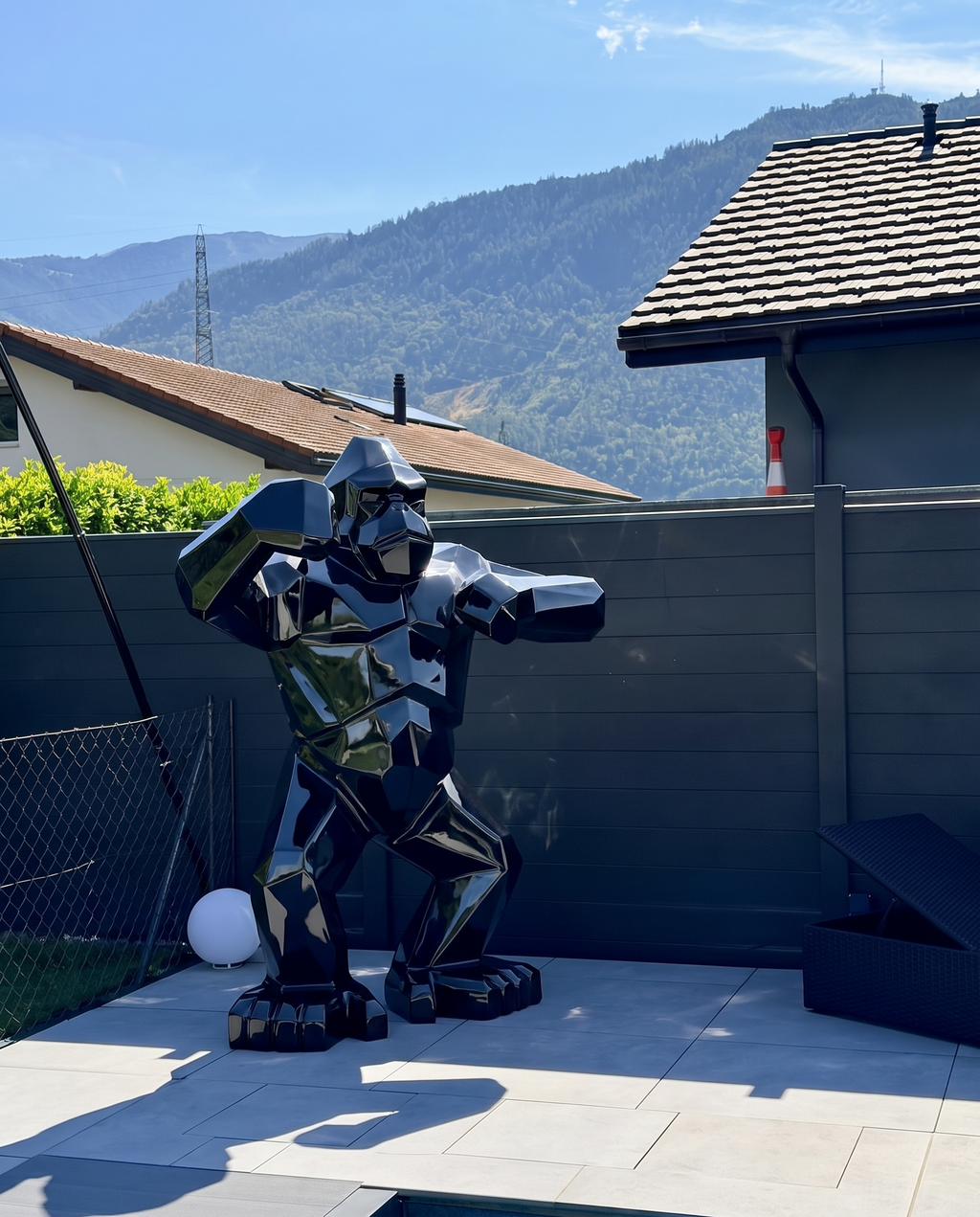Kongari Collection — sculpture gorille origami Noir Onyx H200 cm pour intérieur et extérieur, résine laquée anti-UV, installée dans un jardin face aux Alpes suisses