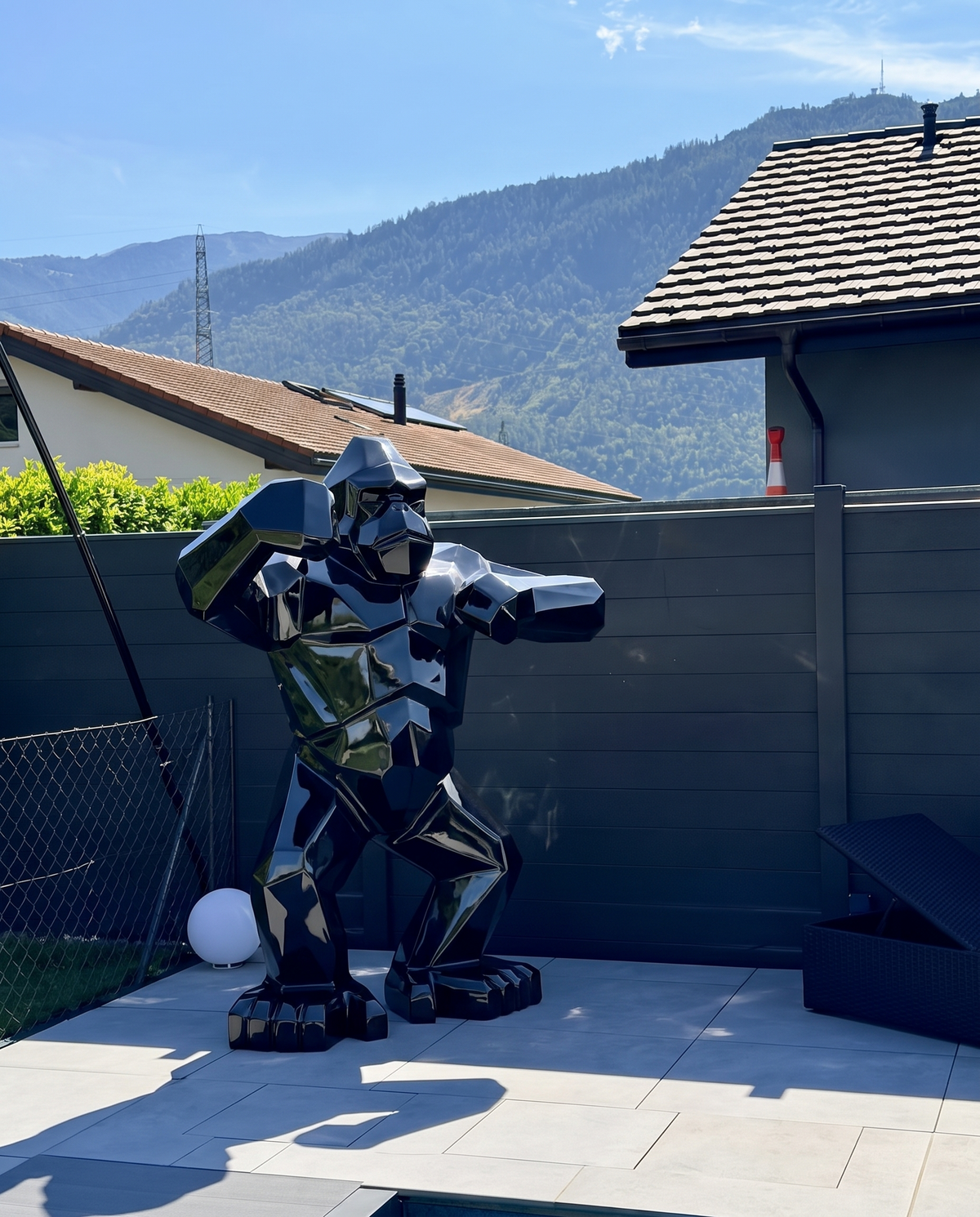 Kongari Collection — sculpture gorille origami Noir Onyx H200 cm pour intérieur et extérieur, résine laquée anti-UV, installée dans un jardin face aux Alpes suisses