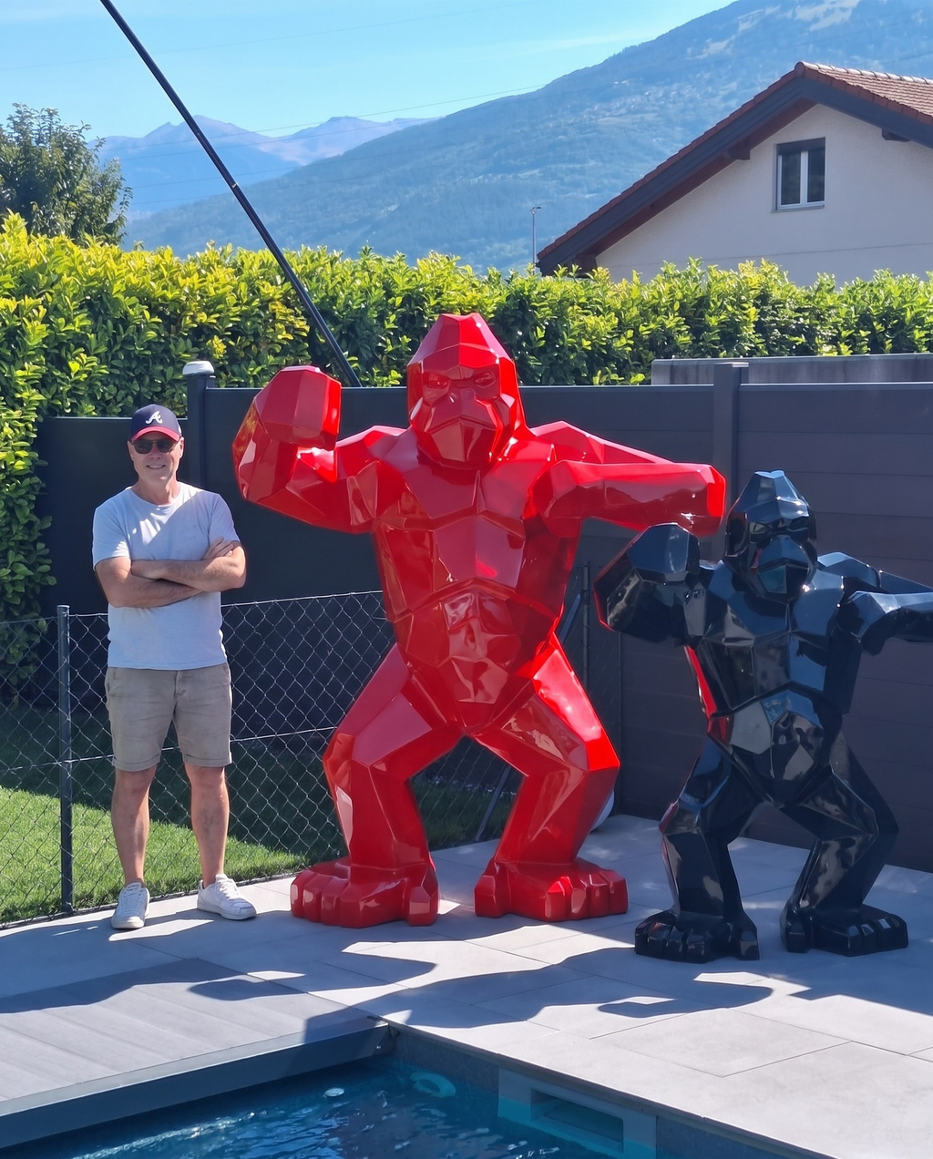 Kongari Collection — sculpture gorille origami Rouge Helvete H200 cm, 2 mètres de haut comparés à un adulte, installée au bord d'une piscine en Valais, Suisse